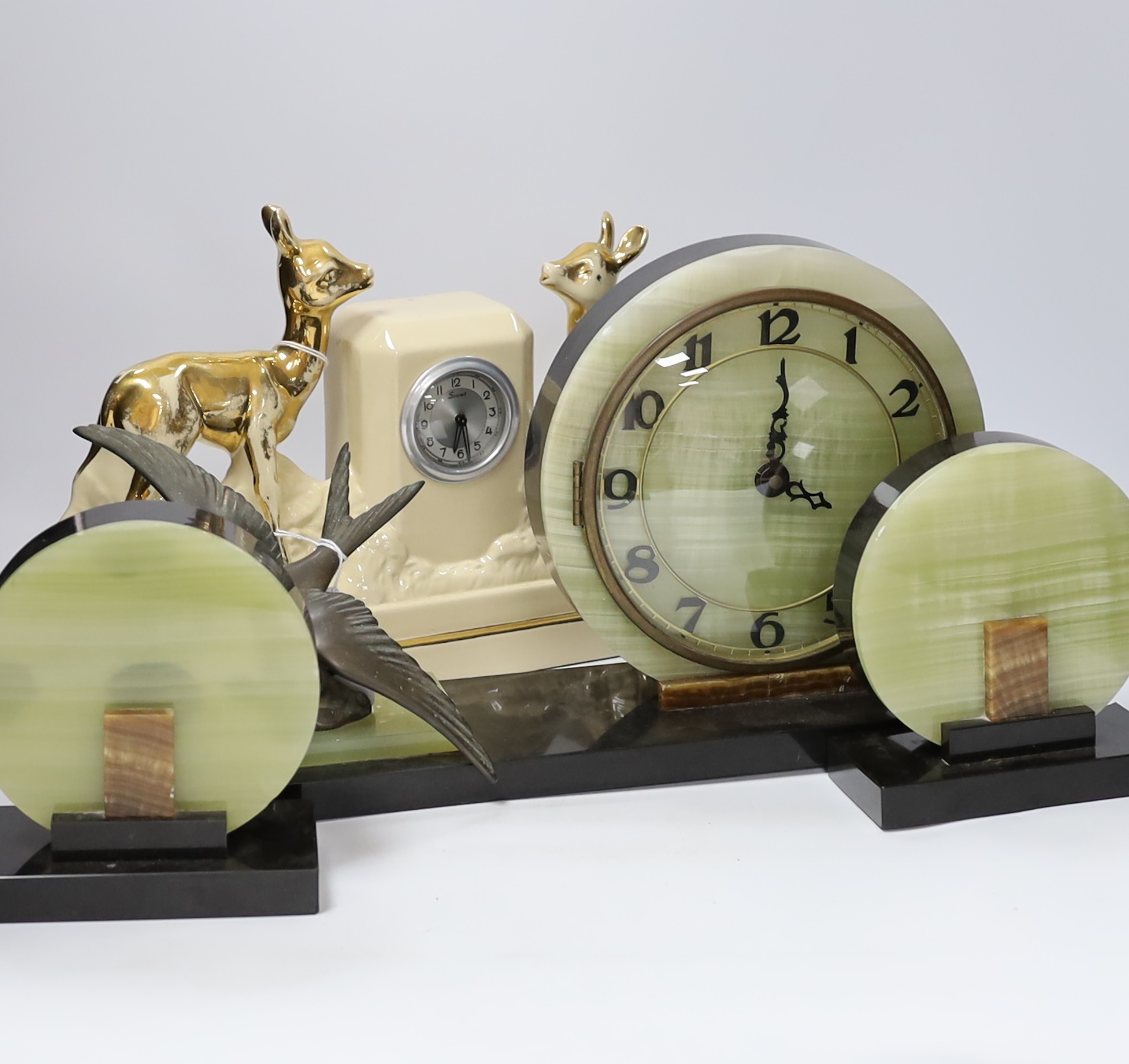 A French Art Deco green onyx clock garniture with Blue bird spelter mount, clock 46cm wide